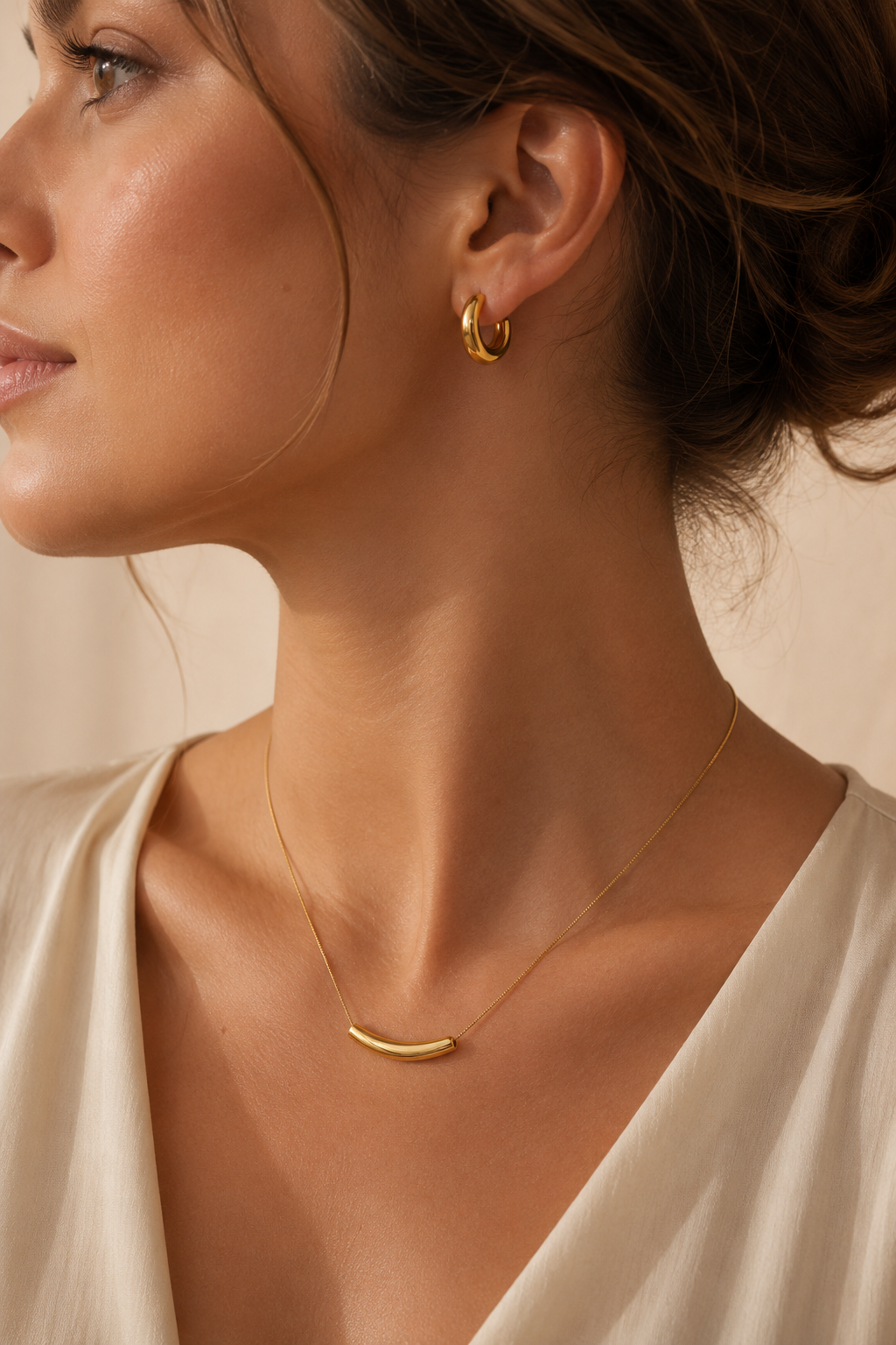Woman wearing Diane gold hoop earrings paired with the Oria gold necklace in an elegant everyday jewelry look