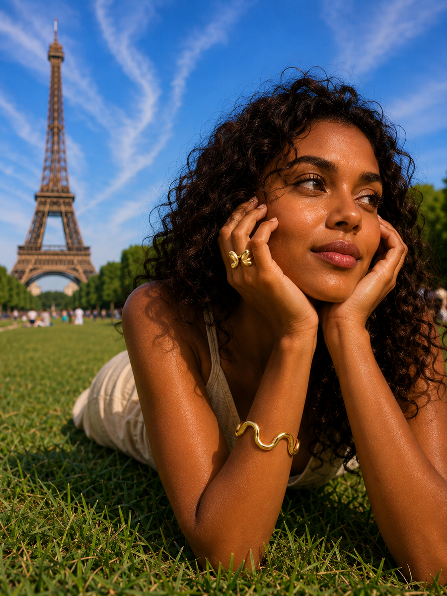 Black curly-haired model wearing Sillage bracelet and Alba butterfly ring near the Eiffel Tower by Amelya Paris