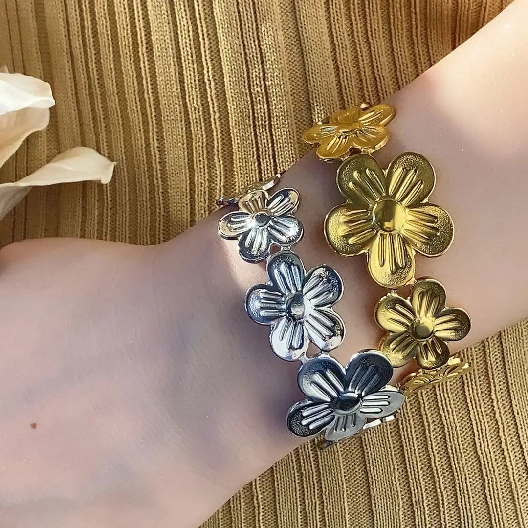 Gold-plated or silver tone stainless steel bracelet with floral detail